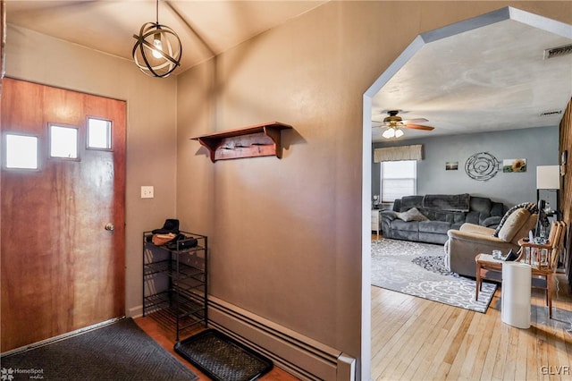 foyer featuring a ceiling fan, plenty of natural light, a baseboard heating unit, and hardwood / wood-style floors