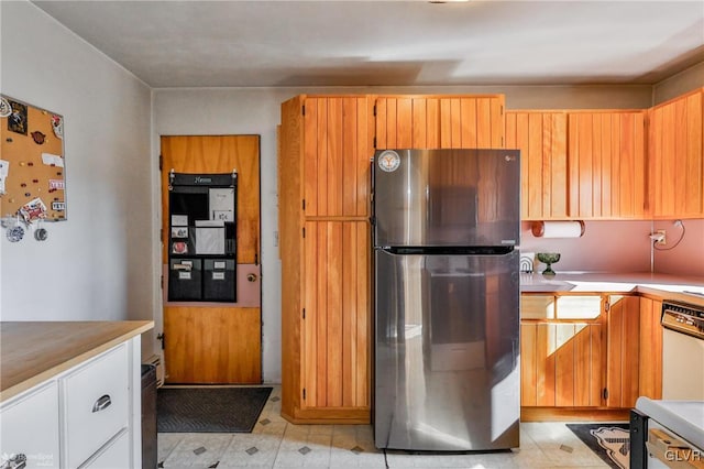 kitchen with light floors, light countertops, dishwasher, and freestanding refrigerator