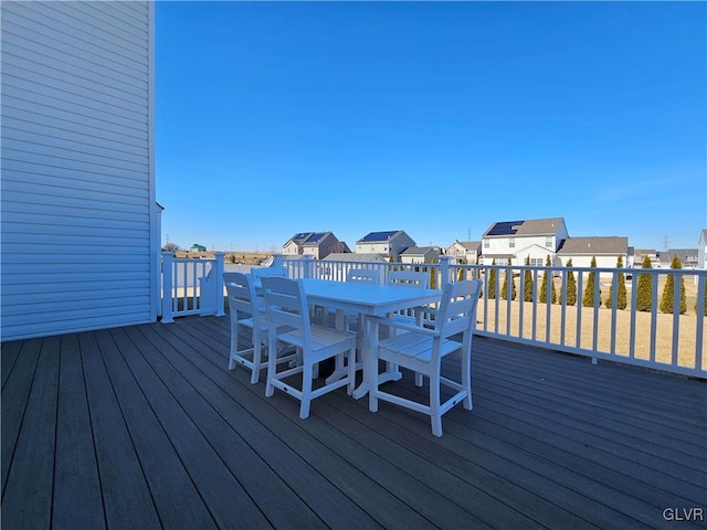 deck with outdoor dining space and a residential view