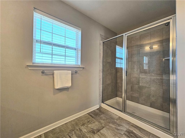 full bath featuring a stall shower and baseboards