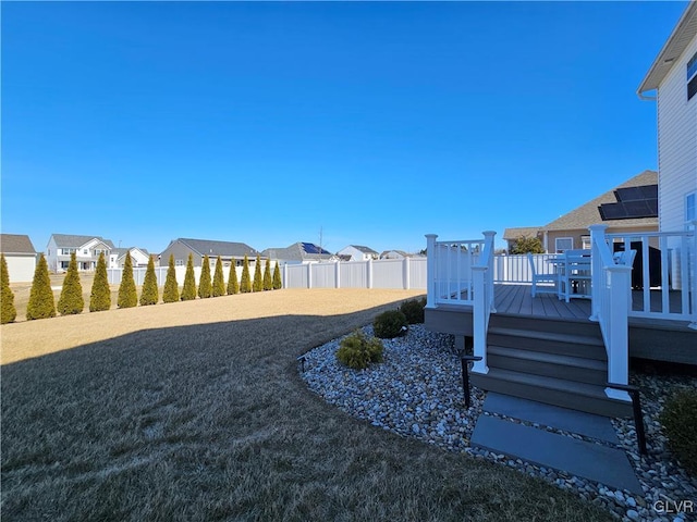 view of yard with a residential view, fence, and a deck