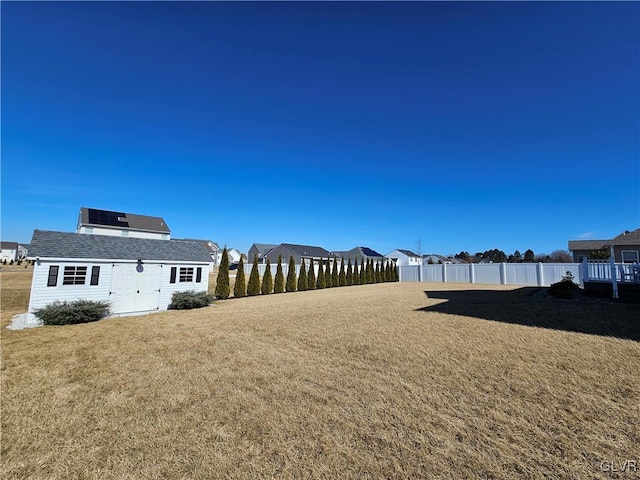 view of yard featuring an outdoor structure, a shed, and fence