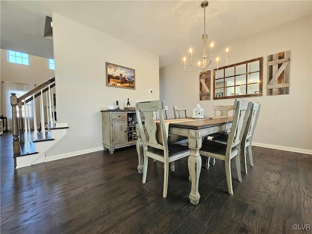 dining space with stairs, a chandelier, baseboards, and wood finished floors