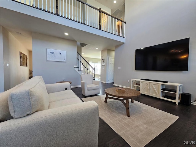 living area with dark wood-style floors, stairway, baseboards, and recessed lighting