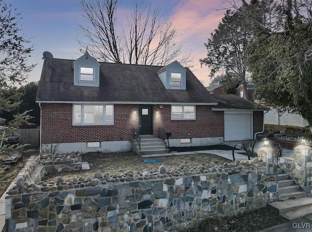 cape cod-style house featuring a garage, crawl space, driveway, and brick siding