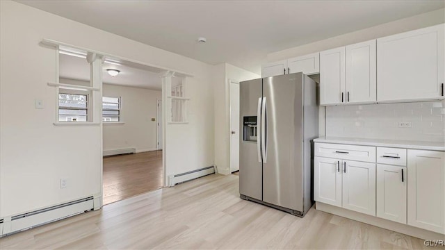 kitchen featuring a baseboard heating unit, white cabinetry, decorative backsplash, and stainless steel fridge with ice dispenser