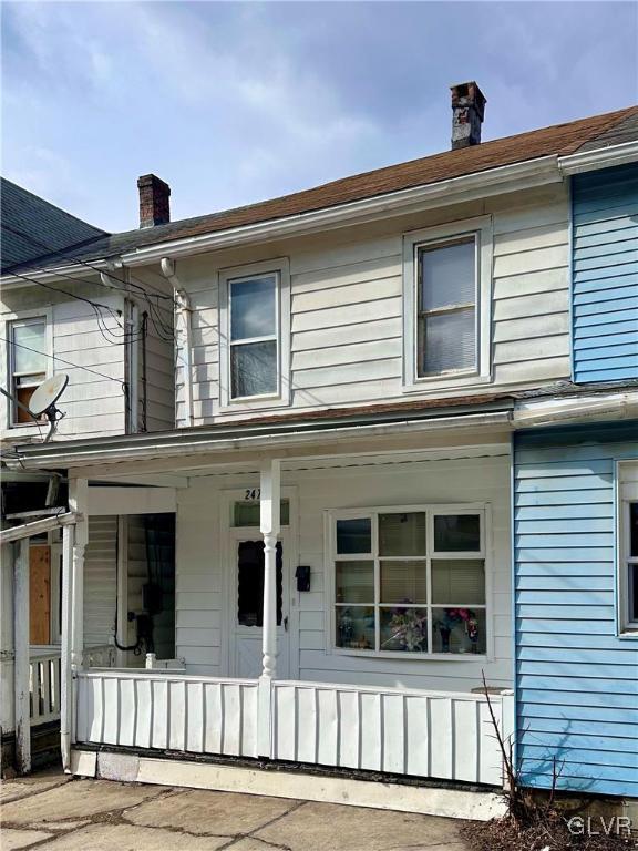 exterior space featuring covered porch and a chimney