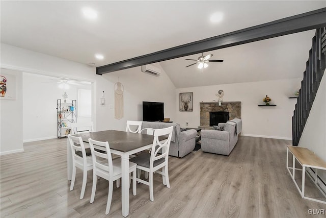 dining area featuring ceiling fan, an AC wall unit, a fireplace, and stairs