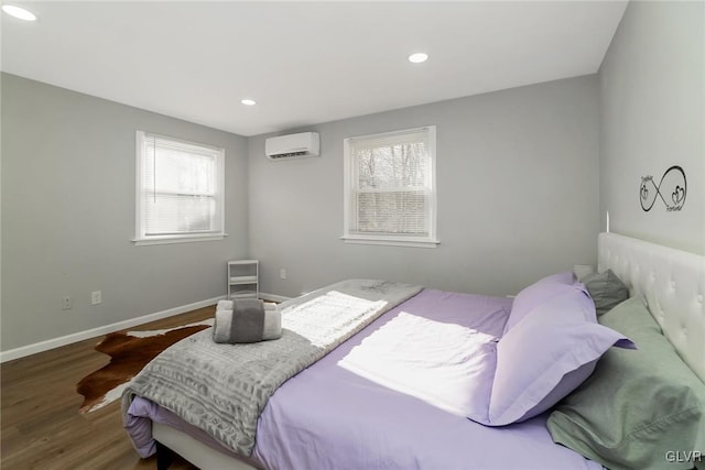 bedroom with recessed lighting, a wall mounted air conditioner, wood finished floors, and baseboards