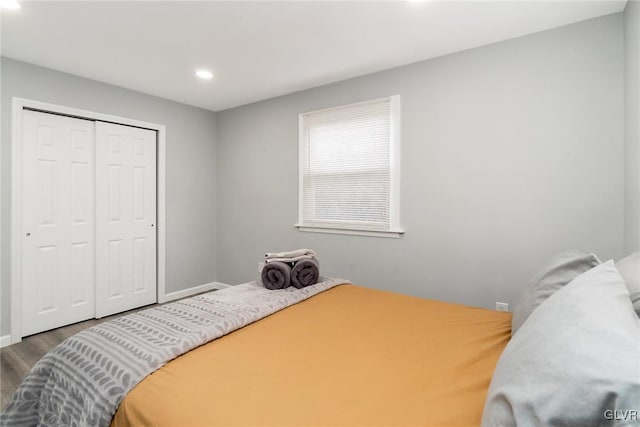 bedroom featuring a closet, wood finished floors, and recessed lighting