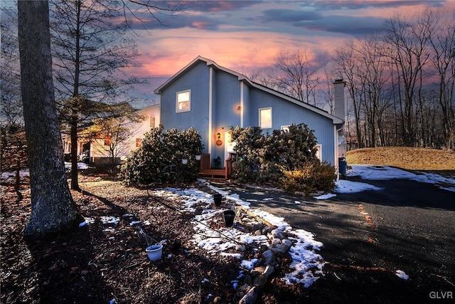 view of front of home featuring driveway and a chimney