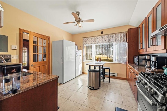 kitchen featuring glass insert cabinets, a baseboard heating unit, a ceiling fan, freestanding refrigerator, and gas range