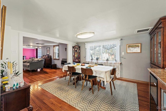 dining area with baseboards, visible vents, and dark wood-type flooring