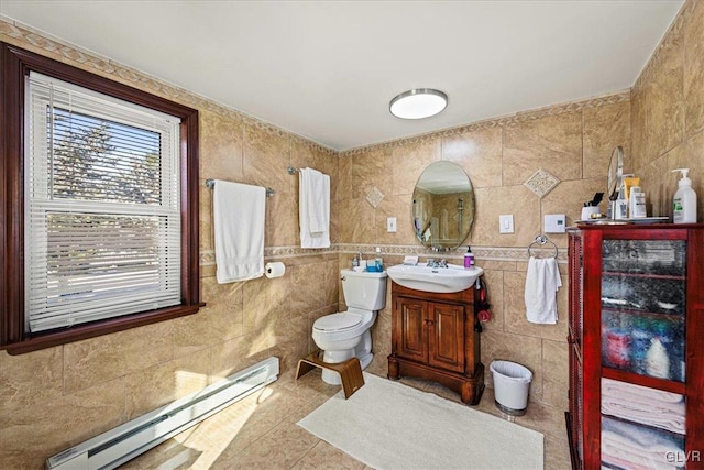 bathroom featuring toilet, a baseboard radiator, tile patterned floors, vanity, and tile walls