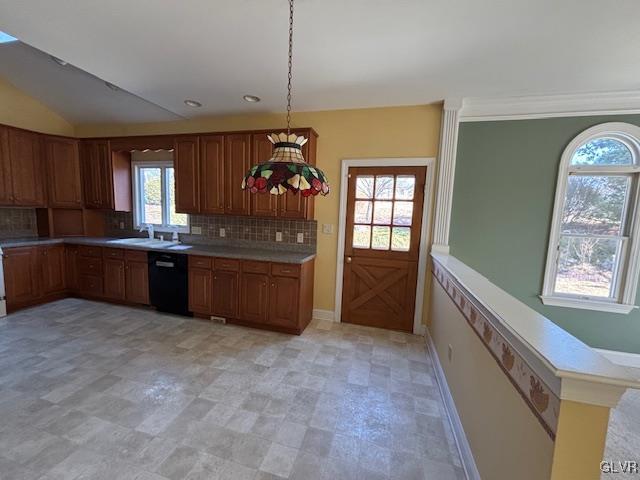 kitchen featuring decorative backsplash, dishwasher, light countertops, and a sink