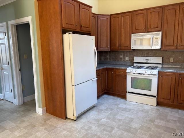 kitchen with brown cabinetry, light floors, white appliances, and tasteful backsplash