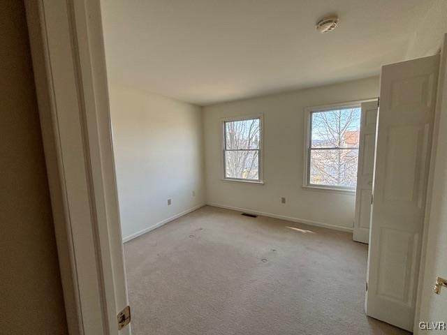 spare room featuring visible vents, baseboards, and carpet