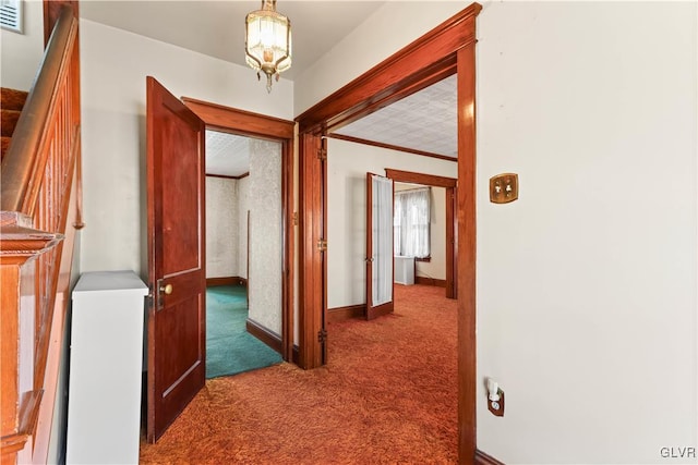 corridor featuring baseboards, visible vents, stairs, crown molding, and carpet flooring