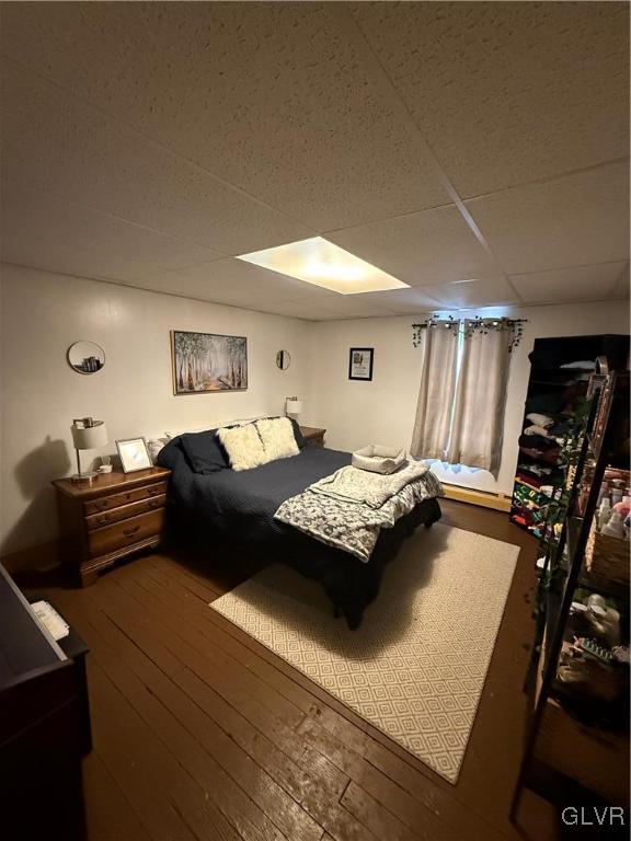 bedroom featuring hardwood / wood-style floors and a drop ceiling