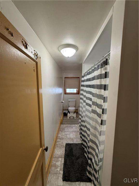 full bathroom with curtained shower and toilet