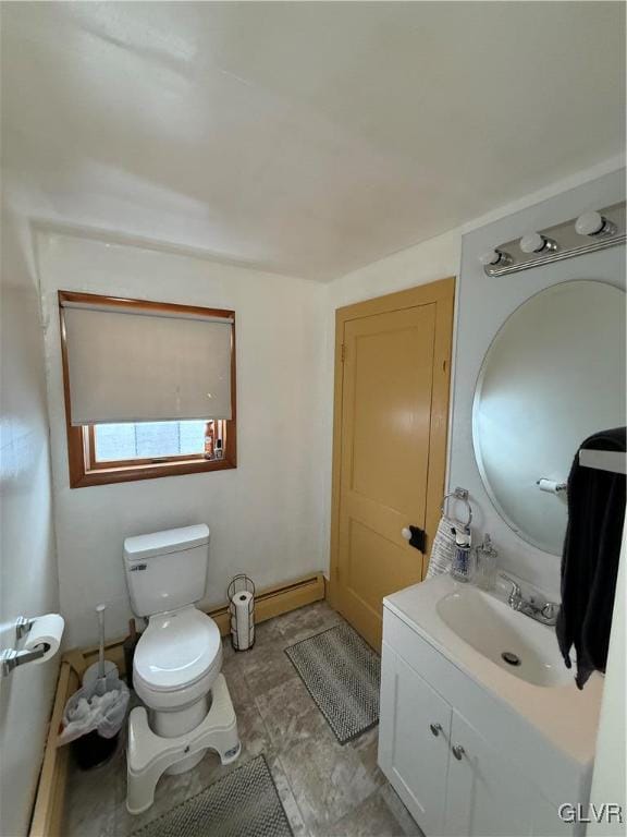 half bathroom featuring baseboard heating, vanity, and toilet