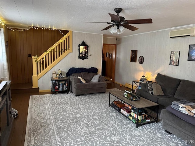 living room with ceiling fan, hardwood / wood-style flooring, stairway, a wall mounted air conditioner, and crown molding