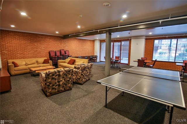 recreation room featuring plenty of natural light and brick wall