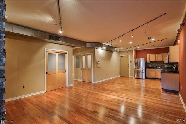 interior space featuring visible vents, electric panel, light wood-style flooring, and baseboards