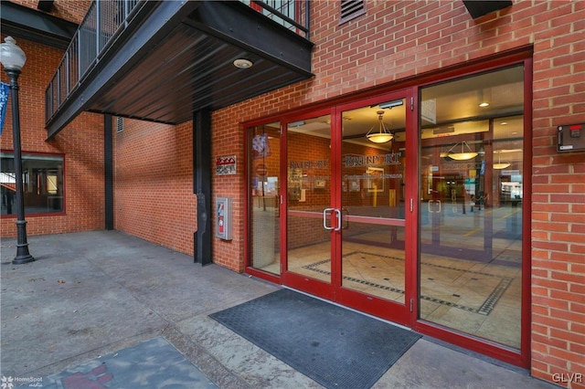 doorway to property featuring brick siding