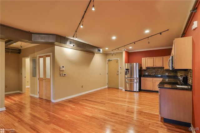 kitchen with dark countertops, light wood-style flooring, stainless steel appliances, and decorative backsplash