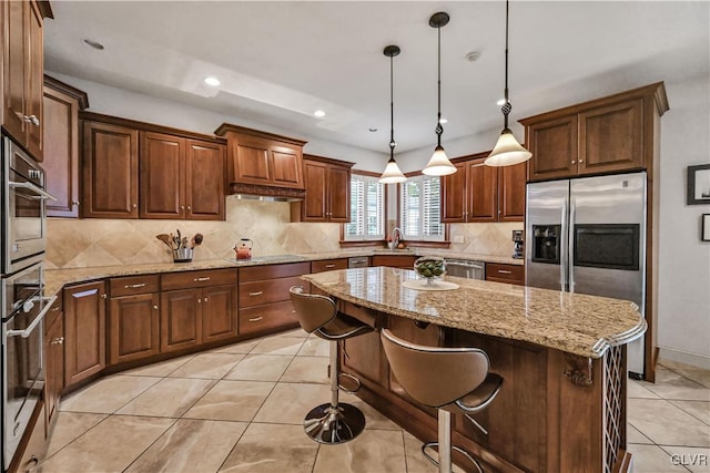 kitchen featuring tasteful backsplash, appliances with stainless steel finishes, light tile patterned flooring, a sink, and a kitchen island