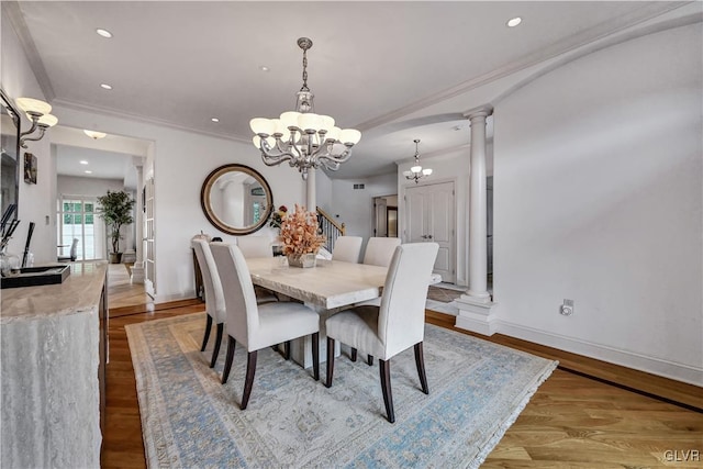 dining area with decorative columns, an inviting chandelier, ornamental molding, wood finished floors, and baseboards