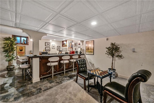 bar with wet bar, arched walkways, and baseboards