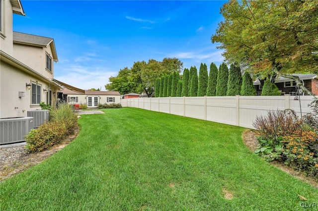 view of yard featuring central AC unit and fence