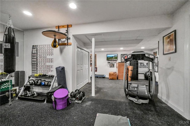 workout room with baseboards, a drop ceiling, and recessed lighting