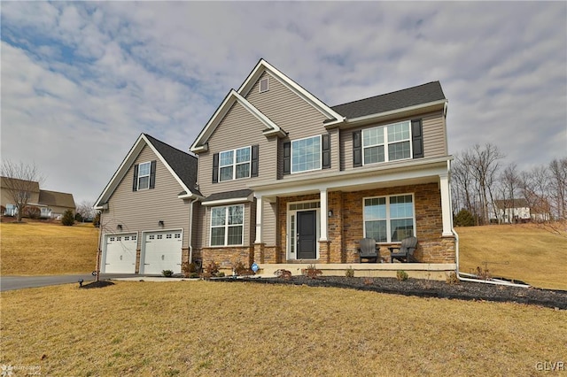 craftsman-style home with an attached garage, covered porch, driveway, and a front yard