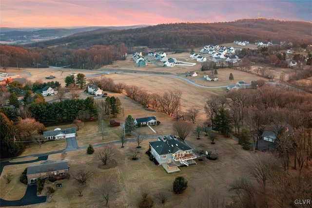 aerial view at dusk with a mountain view and a rural view