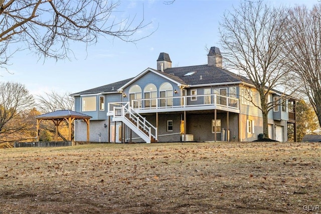 rear view of house featuring a chimney, stairs, a gazebo, a garage, and a deck