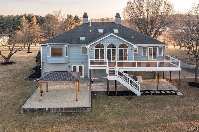 back of property featuring a gazebo, stairway, a lawn, and a patio area