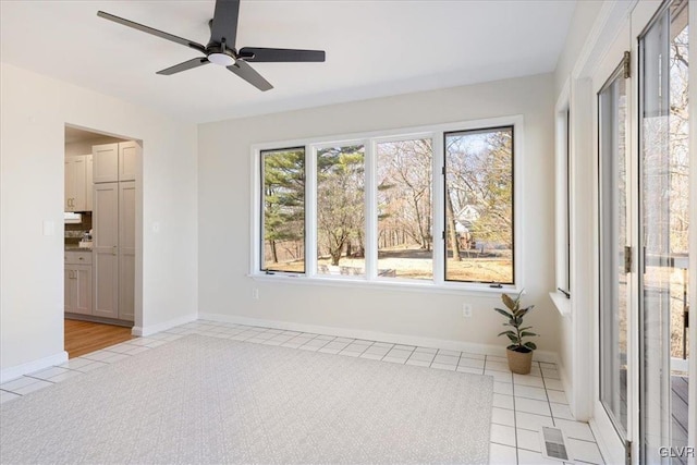 spare room with light tile patterned floors, visible vents, baseboards, and ceiling fan