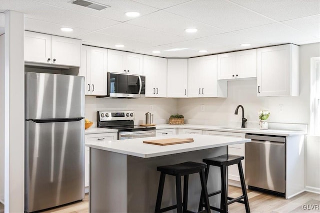 kitchen featuring a sink, visible vents, white cabinetry, and stainless steel appliances