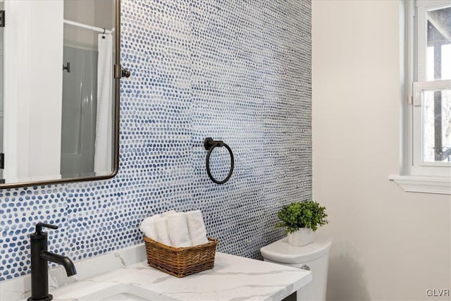 bathroom featuring a shower with curtain, toilet, vanity, and a wealth of natural light