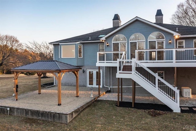 rear view of property featuring a patio, stairs, a gazebo, french doors, and a chimney