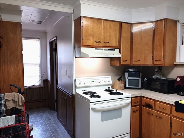 kitchen with electric range, brown cabinetry, light countertops, under cabinet range hood, and black microwave