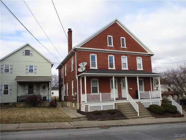 view of front of house featuring covered porch, brick siding, and a chimney