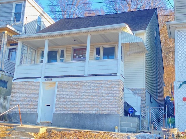 view of property exterior featuring brick siding and a shingled roof