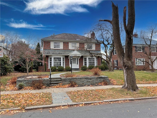 view of front of house with brick siding and a chimney