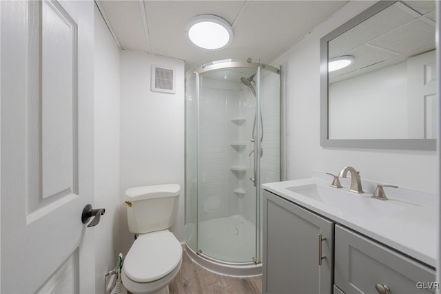 bathroom with visible vents, toilet, a stall shower, vanity, and wood finished floors