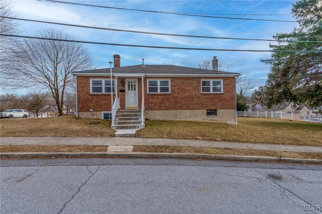 bungalow-style house with brick siding, a front lawn, a chimney, and fence