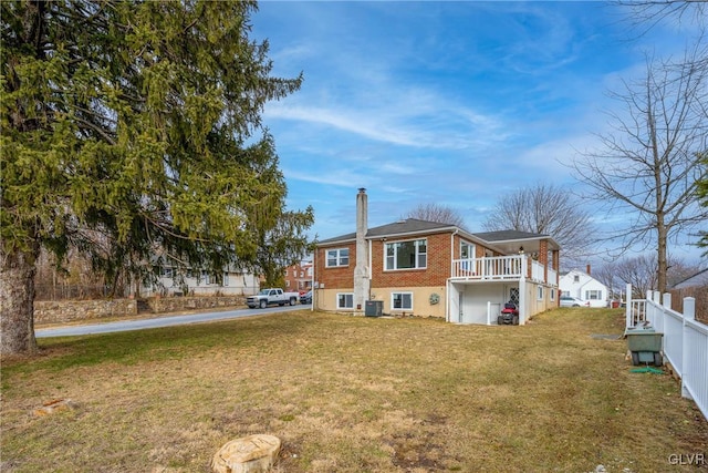 back of property with a yard, brick siding, and a chimney